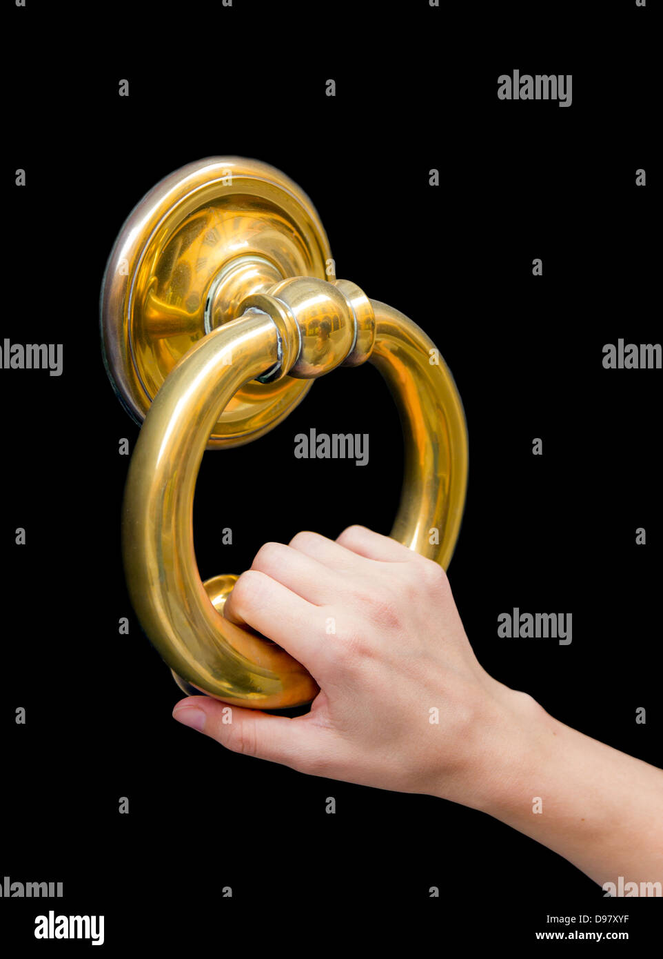 Fiera, piccola mano femmina tenendo un golden door knocker anello su una porta a Modena, Emilia Romagna, Italia Foto Stock
