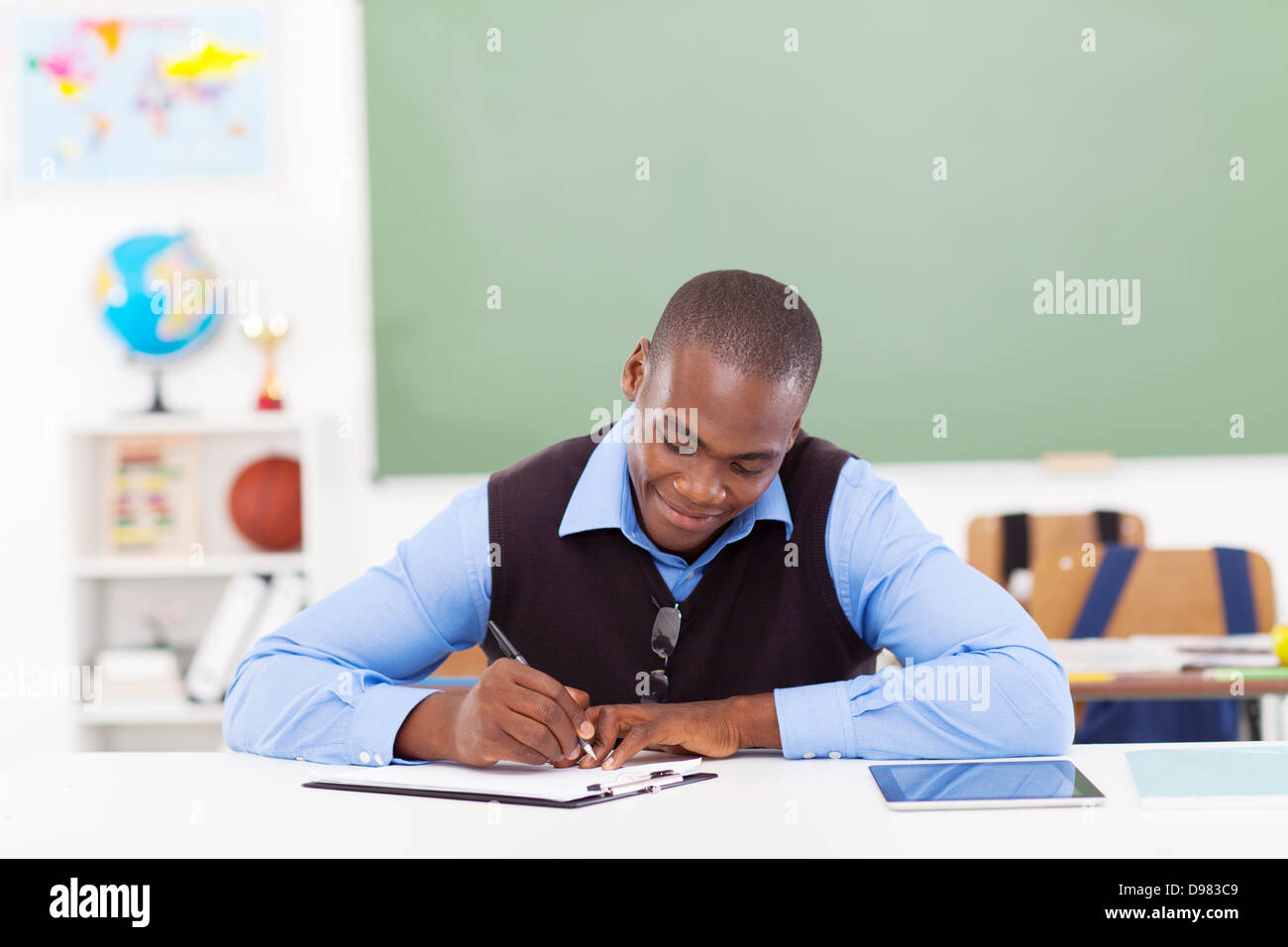 Bel maschio africana insegnante preparare una lezione in aula Foto Stock