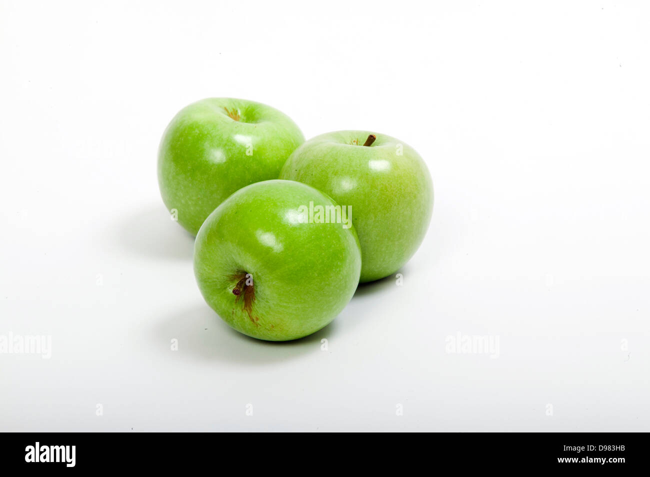 Tre fresco verde brillante le mele Granny Smith su uno sfondo bianco. Foto Stock