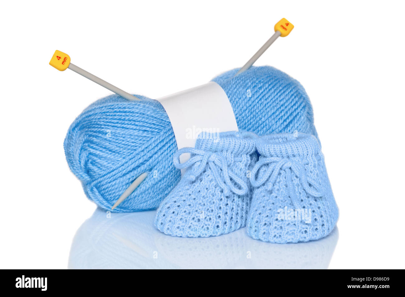 Baby boy scarpine in maglia di lana blu e aghi da maglia, isolata su uno sfondo bianco. Foto Stock