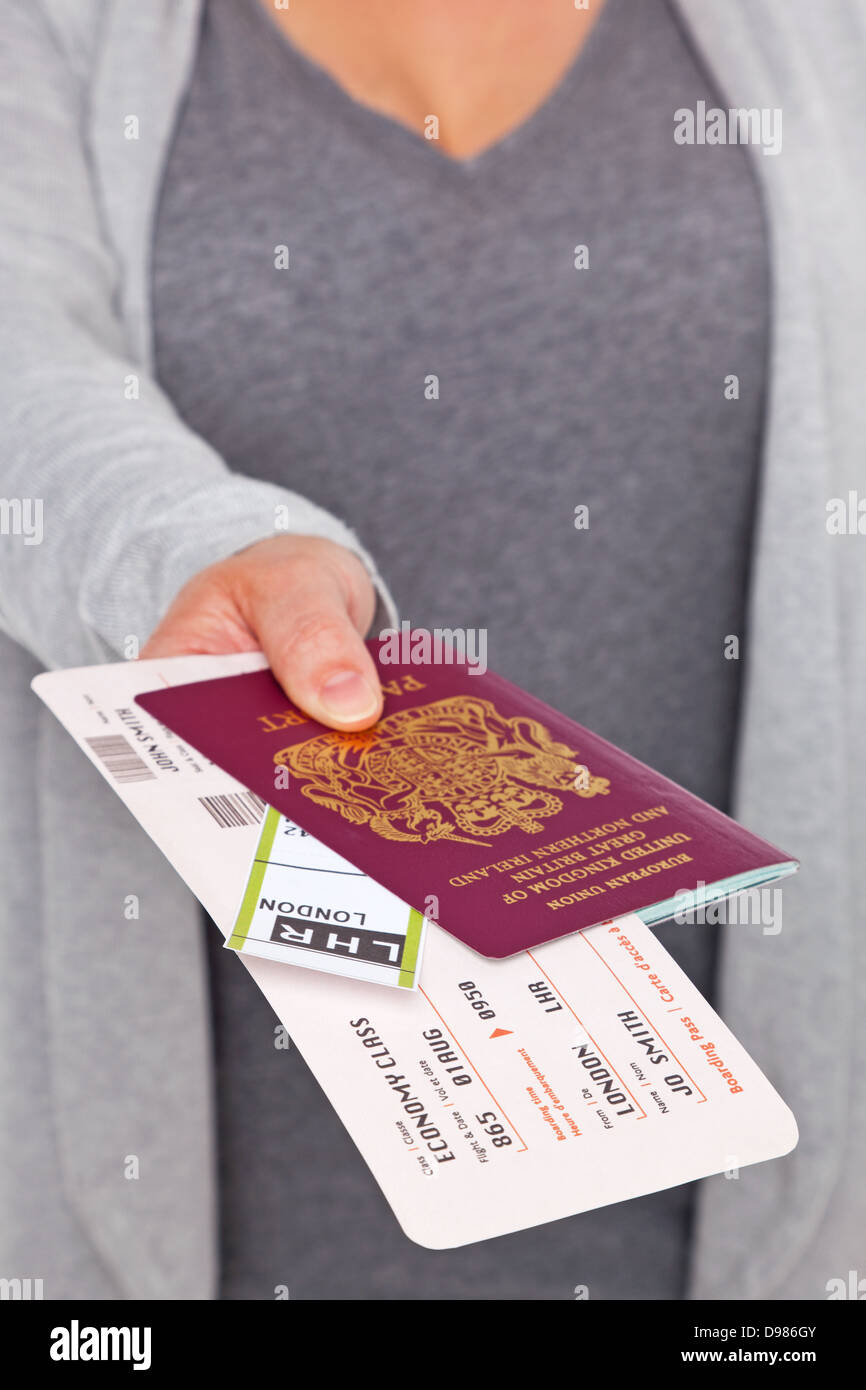 Una femmina di consegnare il suo passaporto e i biglietti al check-in dell'aeroporto. Foto Stock