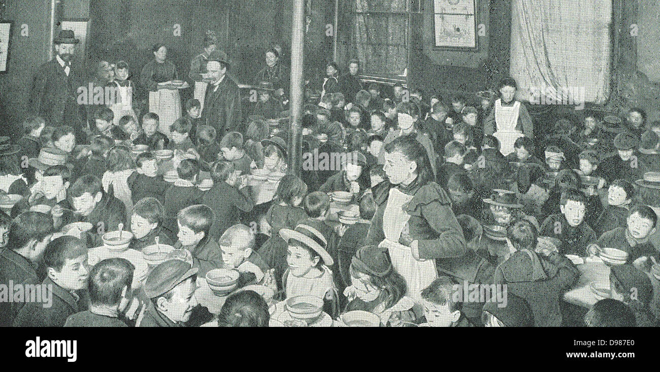 La scuola dei bambini nell'East End di Londra di essere servito con pasti gratuiti, c1910. I figli dei poveri thise distretto della città erano troppo denutrita per essere in grado di concentrarsi sulle loro lezioni senza pasto al loro interno. Foto Stock