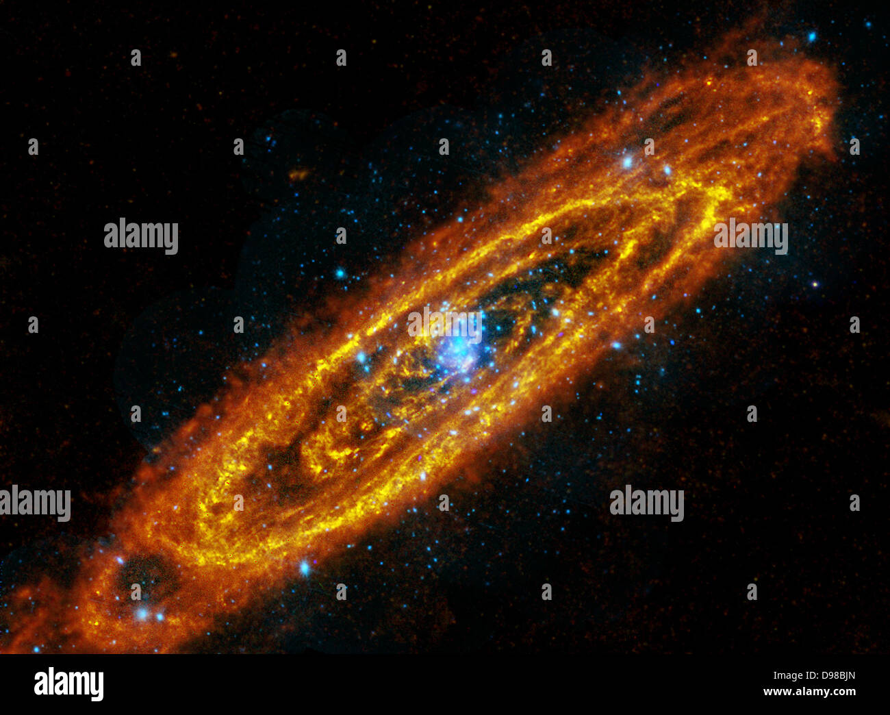 La galassia di Andromeda, M31, è una galassia a spirale a soli 2,5 milioni di anni luce di distanza. Due osservatori spaziali sono combinati per produrre questo intrigante immagine composita di Andromeda, a lunghezze d'onda al di fuori dello spettro visibile. La vista segue le posizioni di questa galassia una volta e future stelle. In riflessi rossastri, i dati di immagine dal grande Herschel osservatorio a raggi infrarossi tracce corsie enorme di polvere, riscaldato da stelle, spazzamento lungo Andromeda di bracci a spirale. La polvere, in congiunzione con la galassia gas interstellare, comprende il materiale grezzo per la futura formazione stellare. Foto Stock