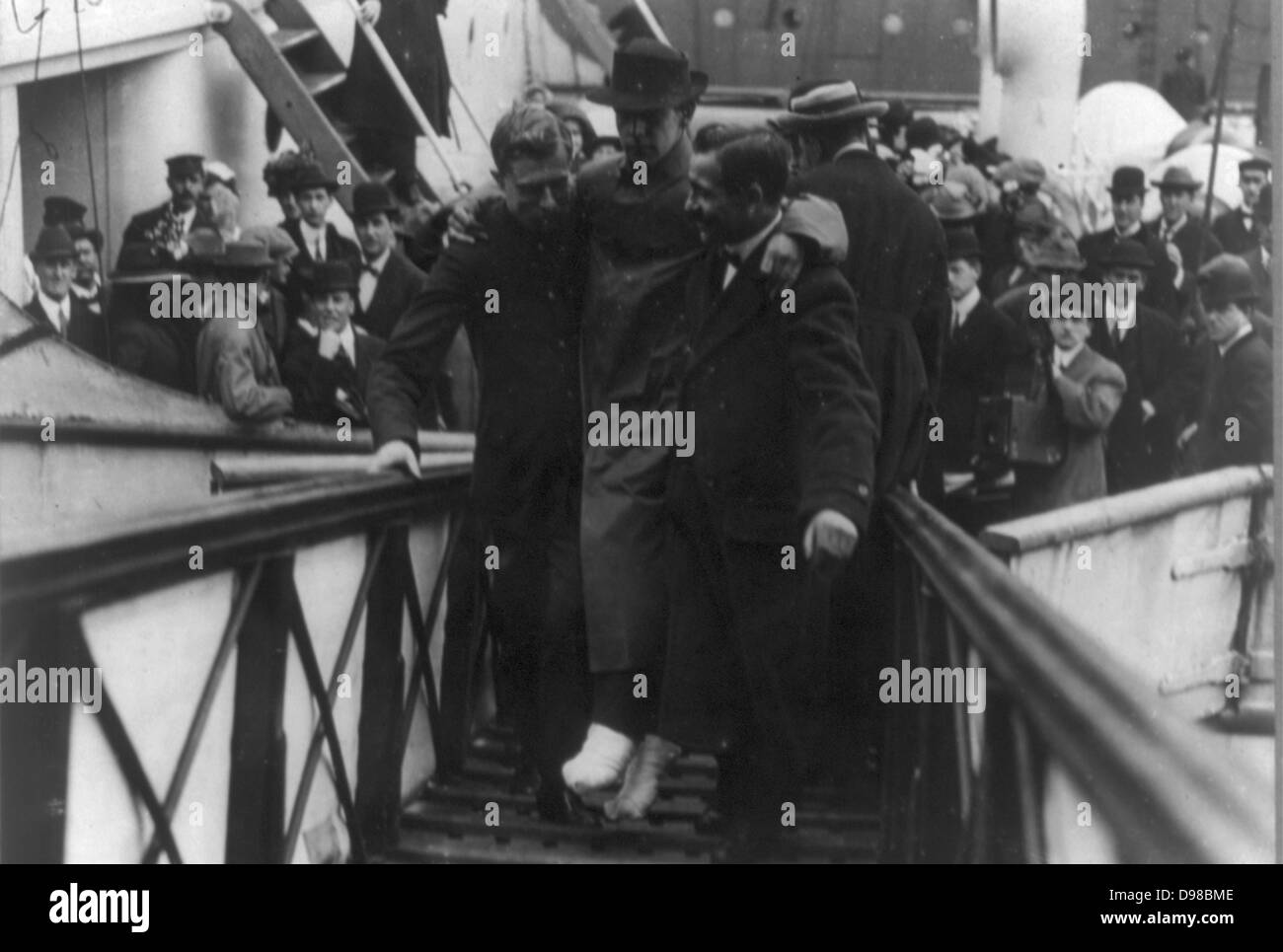 Harold sposa, superstite operatore wireless del Titanic, con piedi bendati, essendo portati fino rampa della nave]. Data di creazione/Pubblicato: c1912 27 maggio. Media: 1 stampa fotografica. Foto Stock