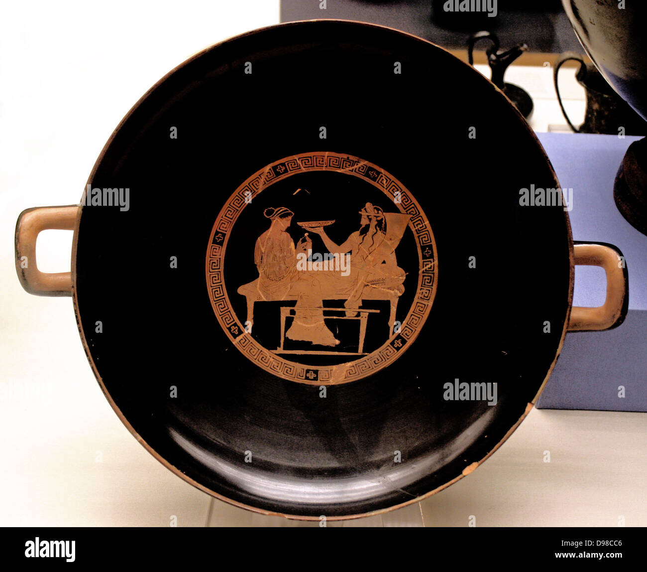 Festeggia il Natale con la morte. Gli interni di questo calice mostra Persefone con Ade, dio della morte e degli inferi. Egli inclinabile su un lettino, tenendo in mano una libagione la ciotola in una mano e una cornucopia nell'altro. L'esterno raffigura Olympian dèi assemblati per bere il partito. Rosso potabile figurato-cup (kylix) realizzato ad Atene attorno al 440-430 A.C. Ha detto di essere dall'Italia. Foto Stock