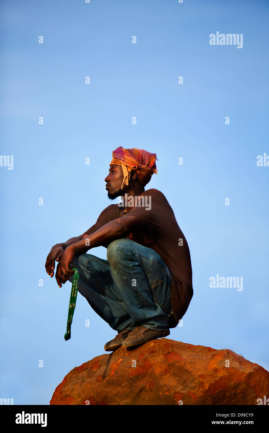 Giovane uomo su roccia, Toubab Dialaw, Senegal Africa Foto Stock