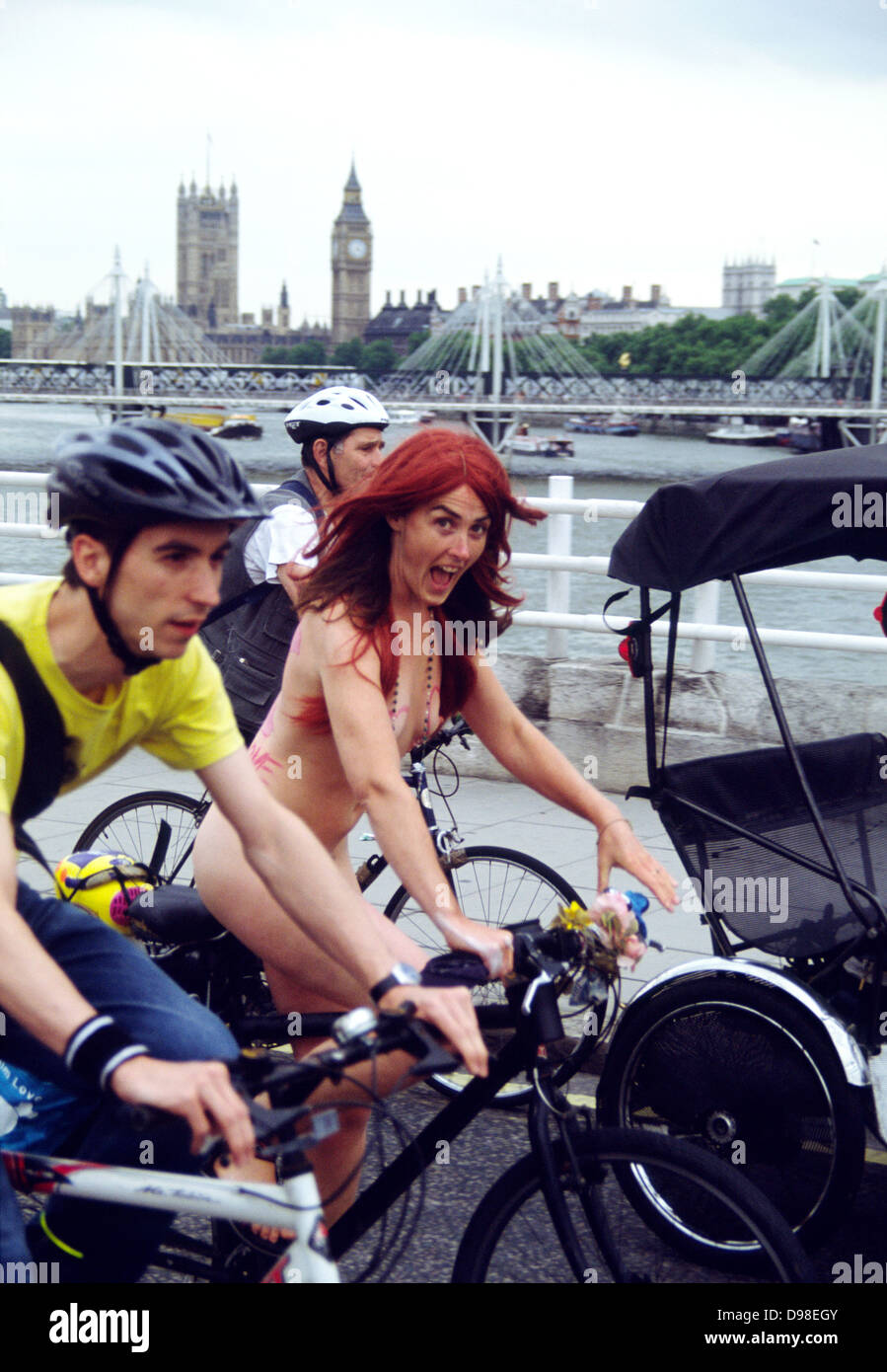 Nudo di donna in bicicletta tra i due uomini vestito sul Westminster Bridge, mondo nudo in Bicicletta a Londra, Inghilterra Foto Stock