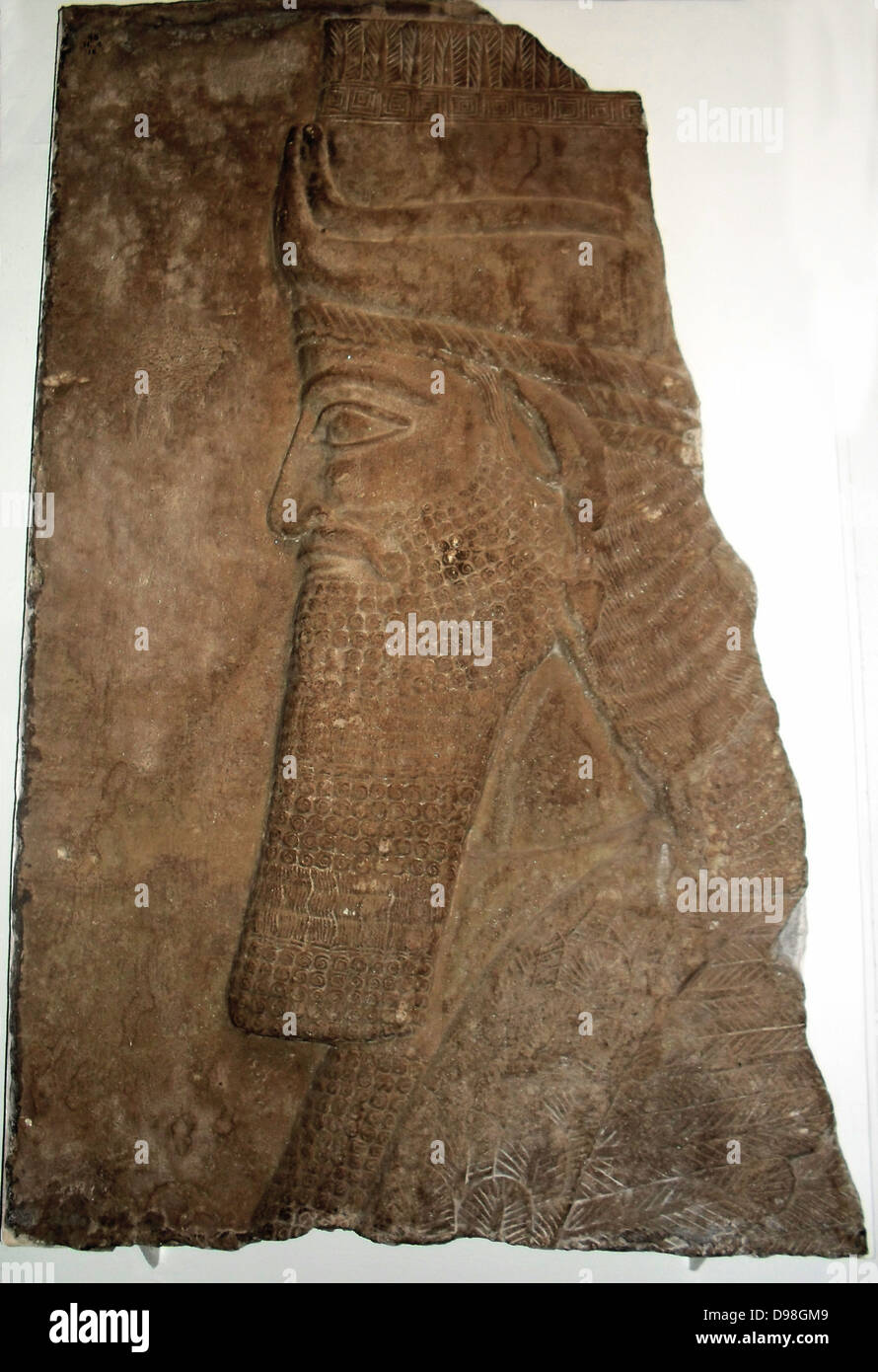 Testa di toro alato. Assira, circa 728 BC. Da Nimrud, Palazzo centrale. Questo frammento di un essere umano con testa di toro alato, da venne Tiglat-Pilèzer III's Palace, è scolpito in basso rilievo come un muro-pannello. Vi è un marcato contrasto con il colossale figure, molto in altorilievo, di entrambe le versioni precedenti e successive. Foto Stock