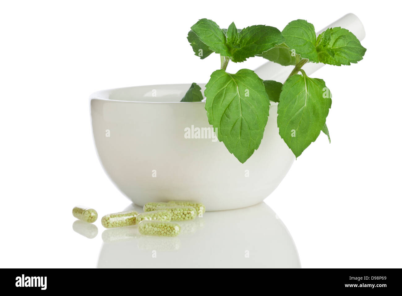 Medicina alternativa - Concetto di mortaio e pestello con rametto di erbe e medicina verde capsule isolati su sfondo bianco Foto Stock