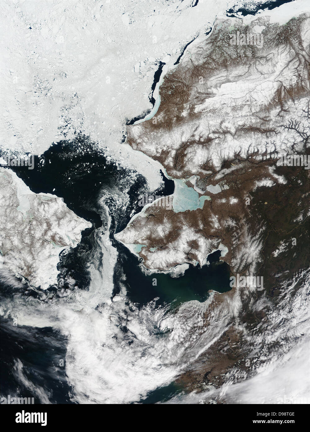 La neve è ritirata dall'Alaska.s il paesaggio e lo stretto di Bering, che separa l'Alaska della penisola di Seward (centro) dalla Siberia, è in gran parte privo di ghiaccio in questa immagine dello spettroradiometro MODIS da Maggio 22, 2002. Mare di ghiaccio nel Kotzebue Sound (a nord della penisola di Seward) è assottigliata notevolmente e ora appare blu cielo, come il riflesso azzurro dell'acqua mostra attraverso dal di sotto. Mare di ghiaccio è ritirata verso nord nel mare Chukchi. Foto Stock