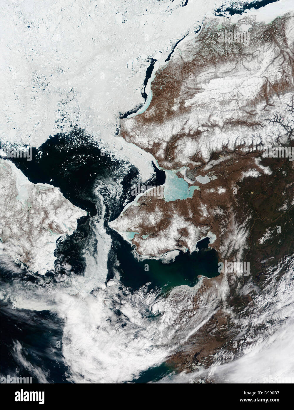 La neve è ritirata dall'Alaska.s il paesaggio e lo stretto di Bering, che separa l'Alaska della penisola di Seward (centro) dalla Siberia,è in gran parte privo di ghiaccio in questa immagine dello spettroradiometro MODIS da Maggio 22, 2002. Mare di ghiaccio nel Kotzebue Sound (a nord della penisola di Seward) è assottigliata notevolmente e ora appare blu cielo, come il riflesso azzurro dell'acqua mostra attraverso dal di sotto. Mare di ghiaccio è ritirata verso nord nel mare Chukchi. Foto Stock