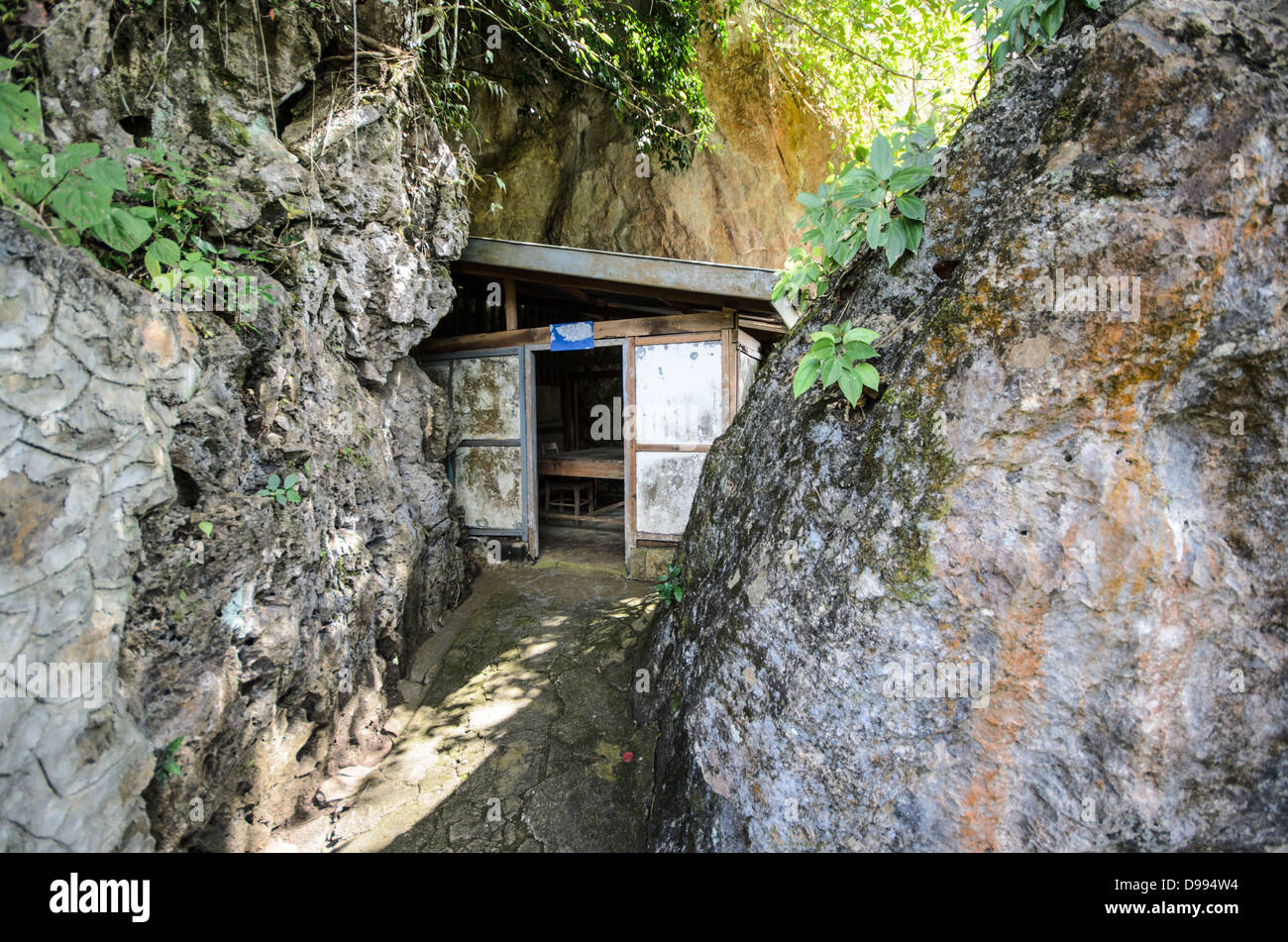 VIENG XAI, Laos: L'ingresso di una delle grotte calcaree che serviva come quartier generale e rifugio per le forze Pathet Lao durante la seconda guerra d'Indocina. Il complesso di grotte di Vieng Xai nella provincia di Houaphanh ha fornito rifugio ai leader e ai combattenti comunisti dal 1964 al 1973 durante le intense campagne di bombardamento degli Stati Uniti. Queste formazioni calcaree naturali sono state trasformate in una città nascosta completa di sale riunioni, ospedali, scuole e alloggi per migliaia di persone. Il Pathet Lao, ufficialmente noto come Esercito Popolare di Liberazione del Laos, utilizzò questa rete di grotte come base primaria Foto Stock
