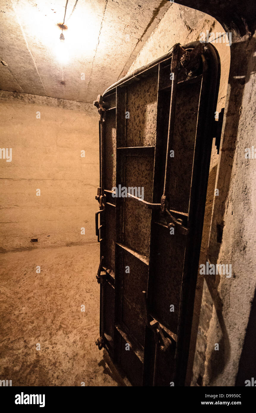 VIENG XAI, Laos — Una porta pesante in acciaio è pronta a sigillare l'ingresso di un'area di emergenza all'interno delle grotte Pathet Lao, dotata di speciali attrezzature di ventilazione. Le grotte servirono come quartier generale e rifugio per la leadership di Pathet Lao durante la guerra del Vietnam, quando il nord-est del Laos dovette affrontare intense campagne di bombardamento americane dal 1964 al 1973. Queste grotte calcaree naturali nel paesaggio carsico della provincia di Houaphanh fornirono protezione alle forze comuniste e ai civili durante quella che divenne nota come la guerra segreta. Il complesso delle grotte ospitava uffici governativi, ospedali, scuole e qu viventi Foto Stock