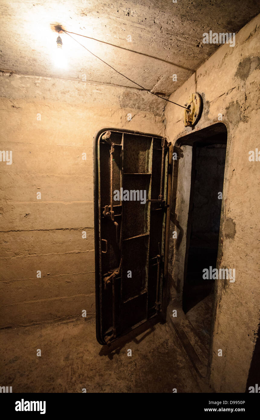 VIENG XAI, Laos — Una porta pesante in acciaio è pronta a sigillare l'ingresso di un'area di emergenza all'interno delle grotte Pathet Lao, dotata di speciali attrezzature di ventilazione. Le grotte servirono come quartier generale e rifugio per la leadership di Pathet Lao durante la guerra del Vietnam, quando il nord-est del Laos dovette affrontare intense campagne di bombardamento americane dal 1964 al 1973. Queste grotte calcaree naturali nel paesaggio carsico della provincia di Houaphanh fornirono protezione alle forze comuniste e ai civili durante quella che divenne nota come la guerra segreta. Il complesso delle grotte ospitava uffici governativi, ospedali, scuole e qu viventi Foto Stock