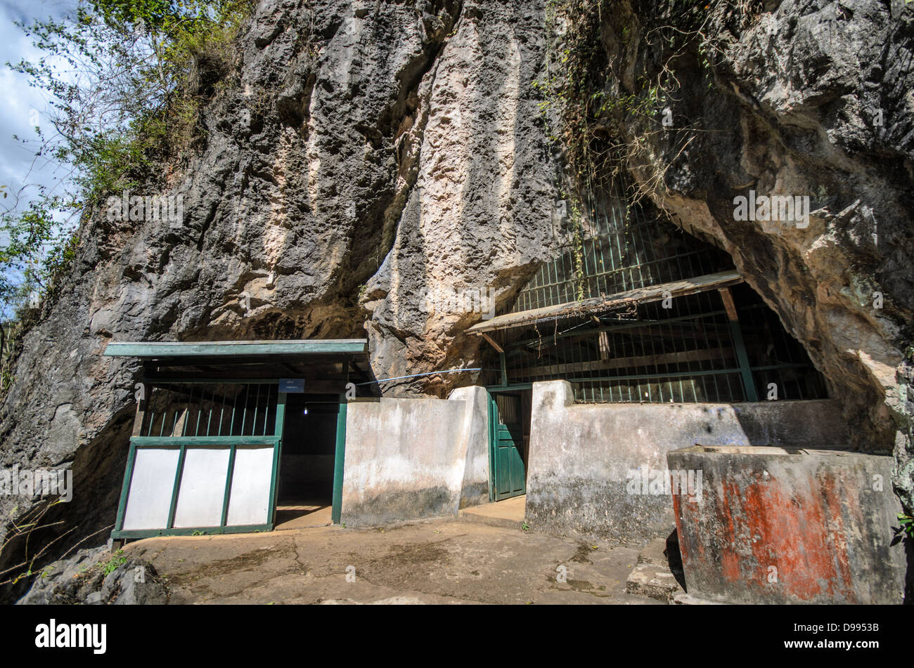 VIENG XAI, Laos - Un ingresso nascosto conduce al complesso di grotte di Pathet Lao a Vieng Xai, una rete di grotte calcaree che serviva come quartier generale e rifugio per le forze comuniste Pathet Lao durante la seconda guerra d'Indocina dal 1964 al 1973. Le grotte fornirono rifugio a migliaia di persone, compresi i leader politici, durante la vasta campagna di bombardamenti degli Stati Uniti nota come Guerra segreta. Questo sistema di grotte ospitava scuole, ospedali, sale riunioni e alloggi scavati nel paesaggio carsico del Laos settentrionale. Le grotte di Vieng Xai sono ora conservate come sito storico, offrendo INS Foto Stock