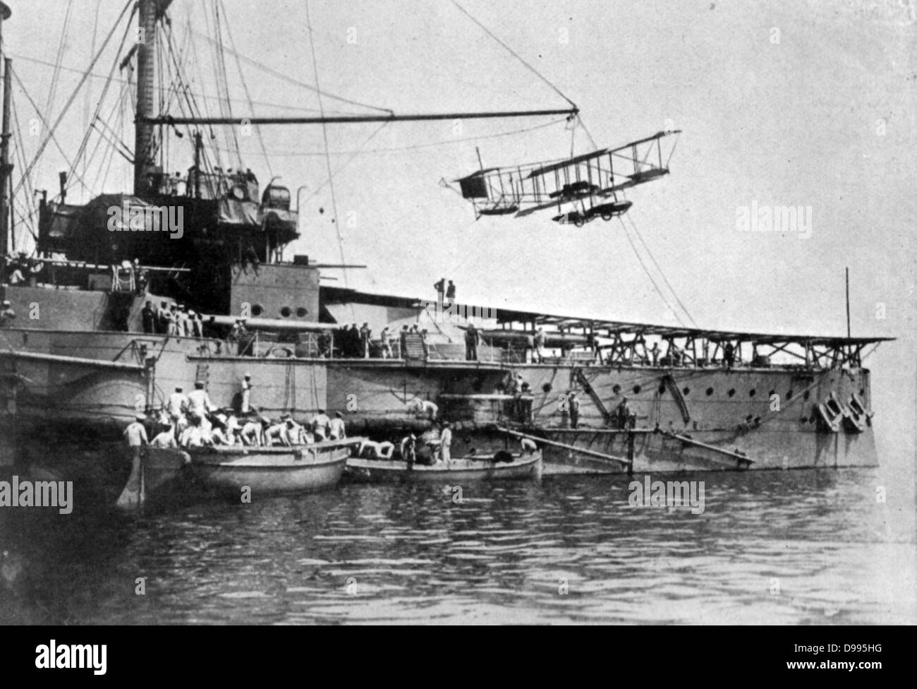 La British Royal Navy nave da guerra con la piattaforma di lancio per biplano che è sospeso al di sopra di esso, c1914. Foto Stock