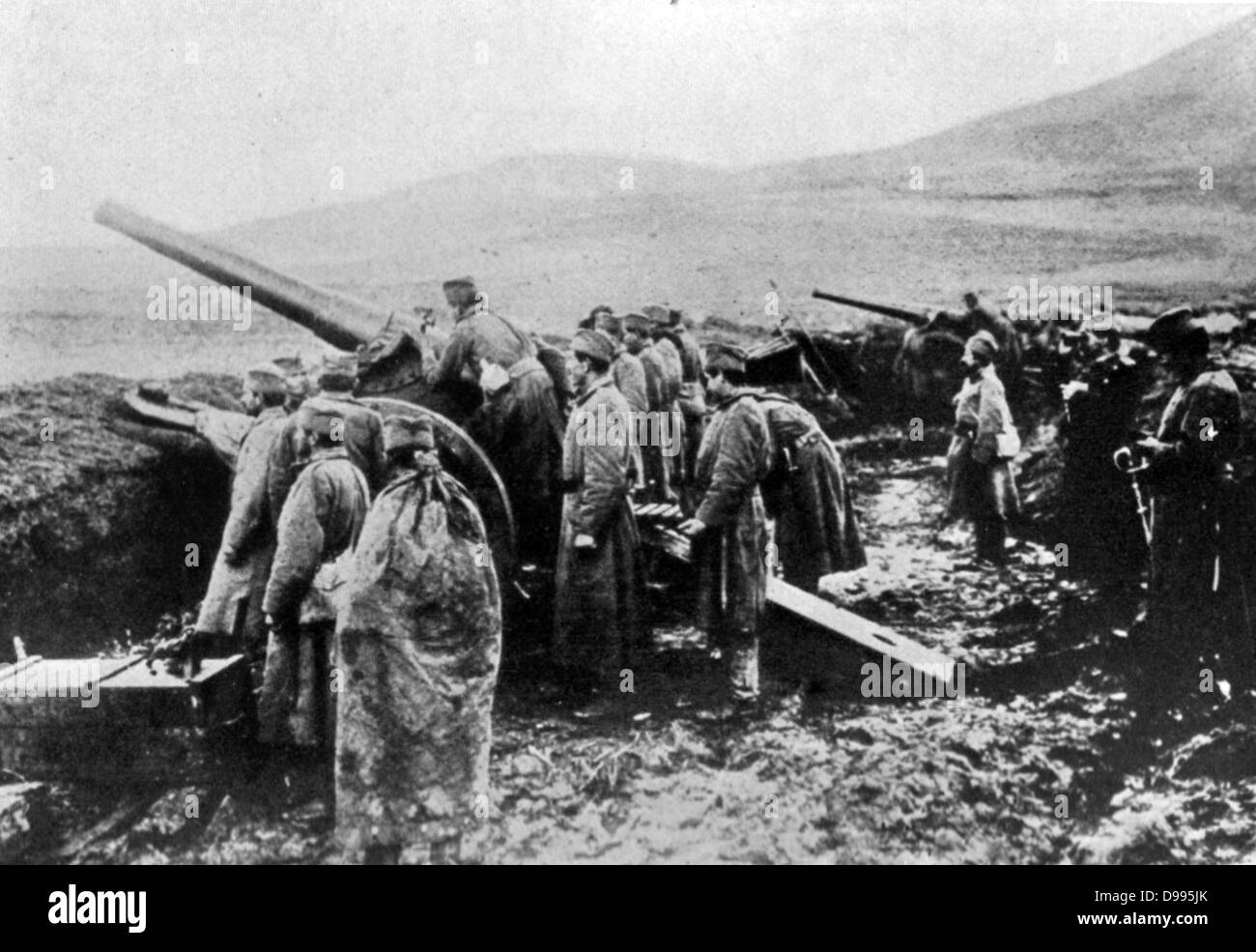 Un serbo di artiglieria pesante batteria, uomini in piedi in umido, fortificazione fangoso, guardando verso l'esterno nella stessa direzione come le pistole sono rivolti. Austro-Hungary invaso la Serbia nel luglio 1914. Foto Stock
