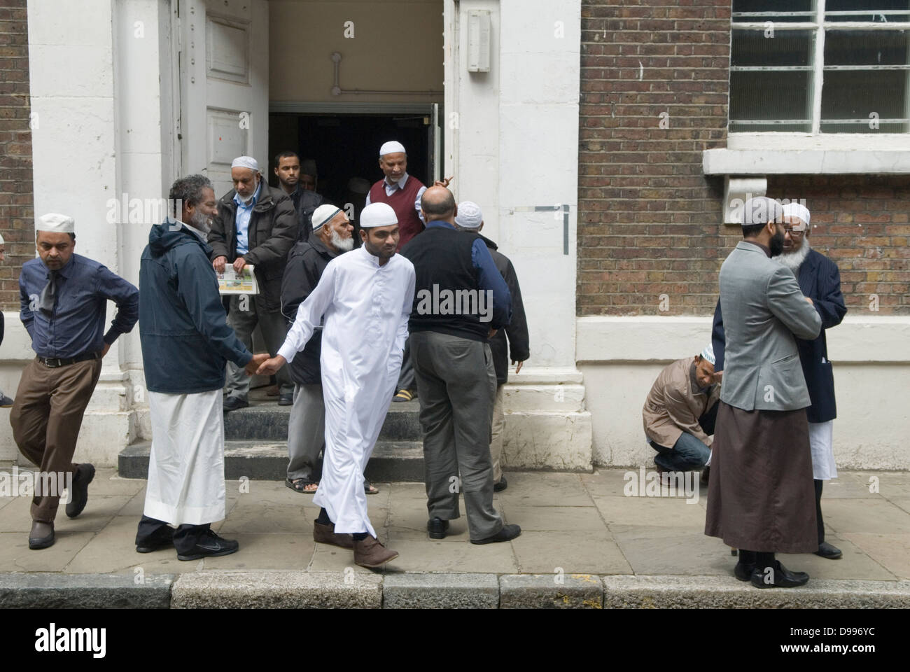 Uomini musulmani che lasciano il venerdì preghiere Jamme Masjid Moschea, Brick Lane Fournier Street ingresso Spitalfields Londra E1. 2013 UK 2010S HOMER SYKES Foto Stock