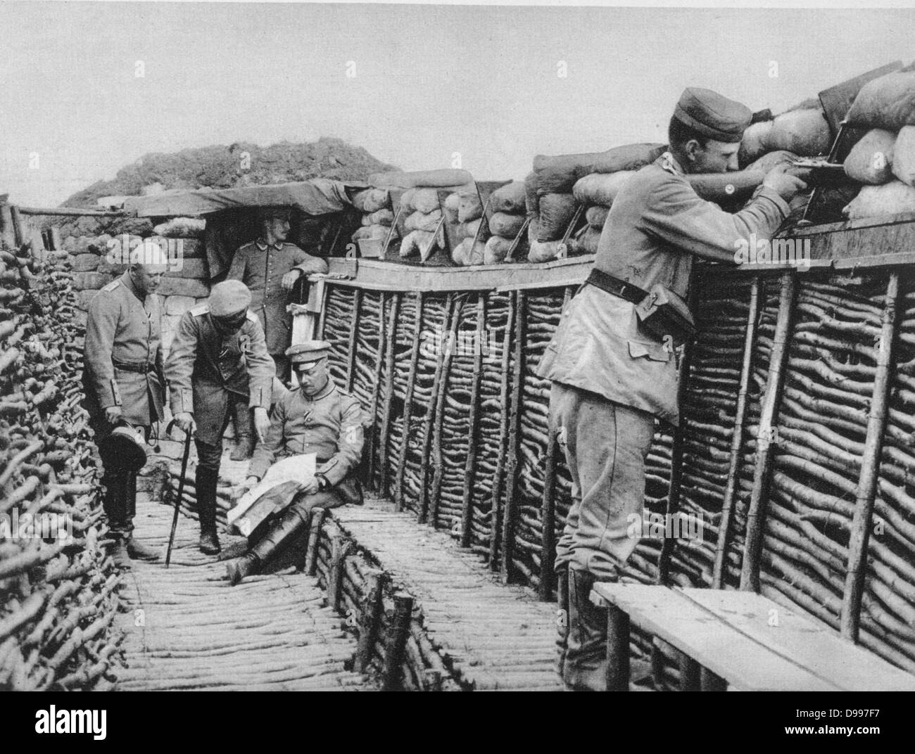 I Guerra Mondiale 1914-1918: View all'interno delle trincee tedesche in Francia, 1915. I funzionari sono esaminando progetti mentre un rifleman sta mantenendo guarda dietro sacchi di sabbia. Militare, esercito, soldato, arma, Smallarms Foto Stock