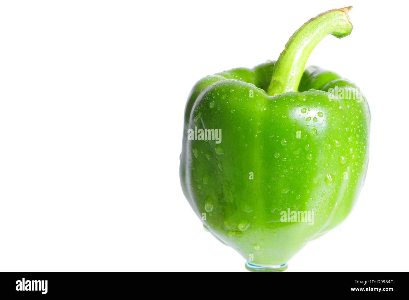 Ripresa macro di un peperone verde su uno sfondo bianco con gocce d'acqua Foto Stock