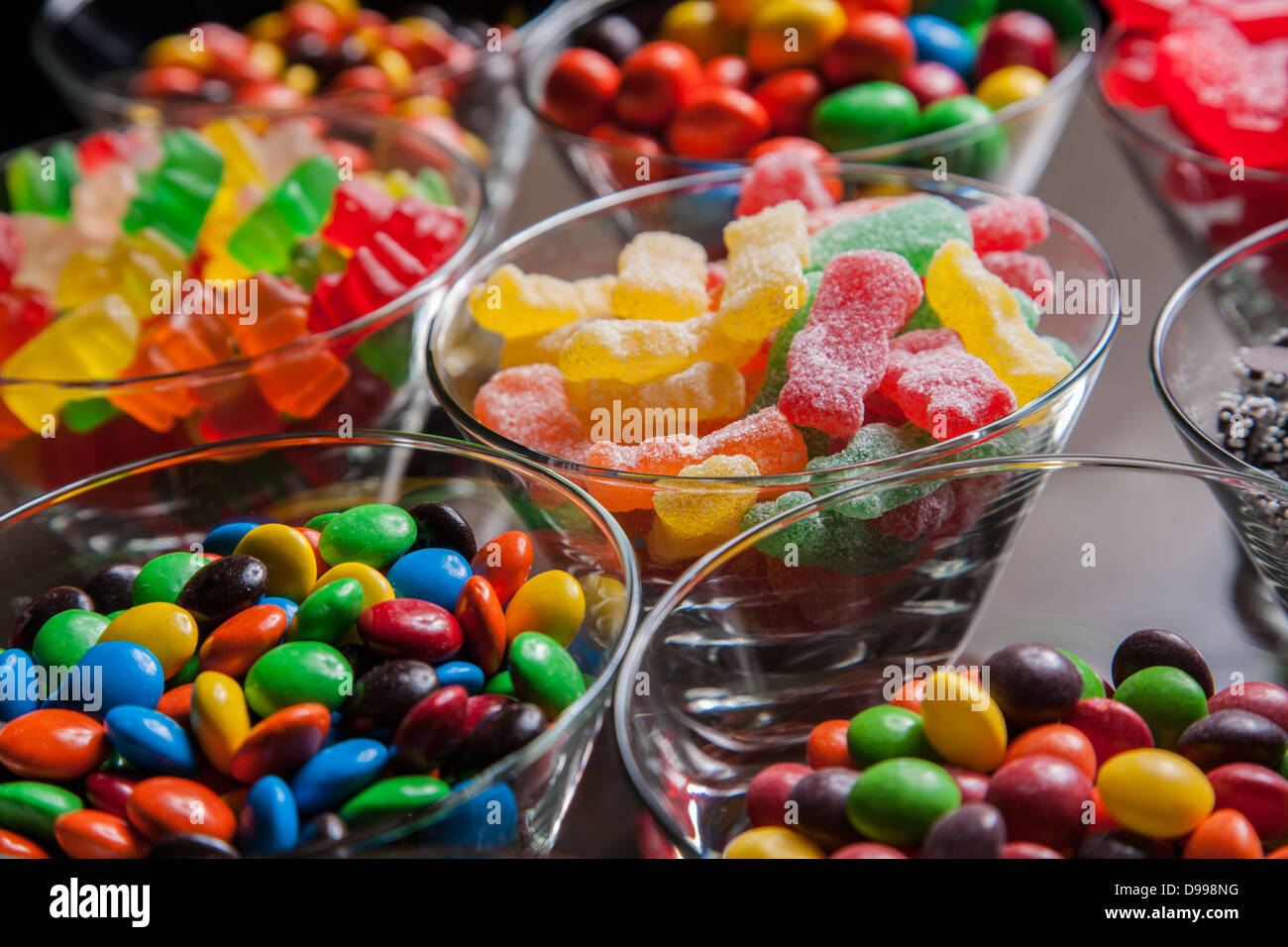 Colorati misti caramelle in chiaro di piccole ciotole in vetro Foto Stock