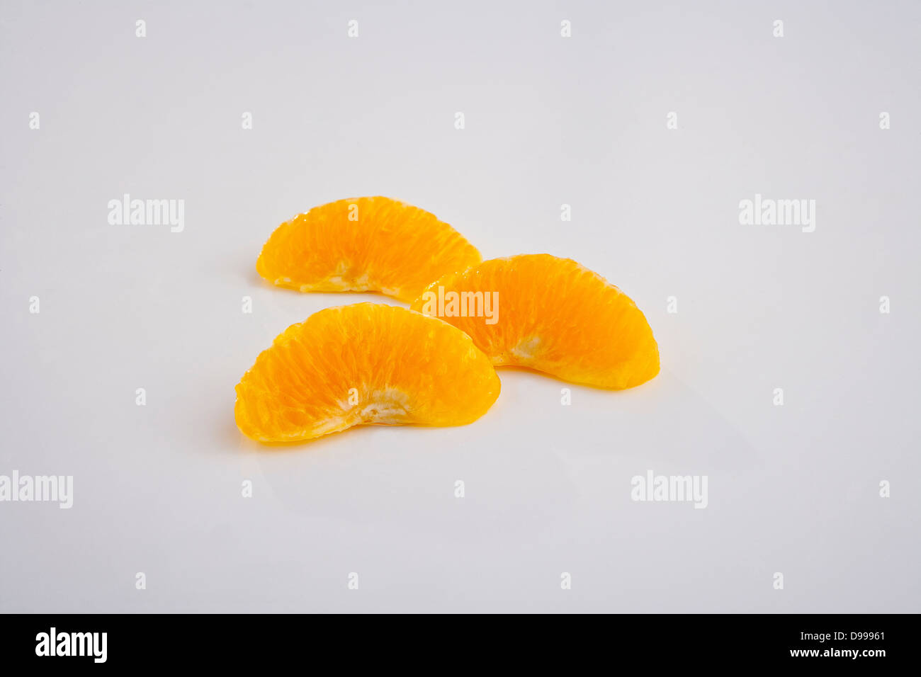 Tre spicchi d'arancia e sezioni su bianco Foto Stock