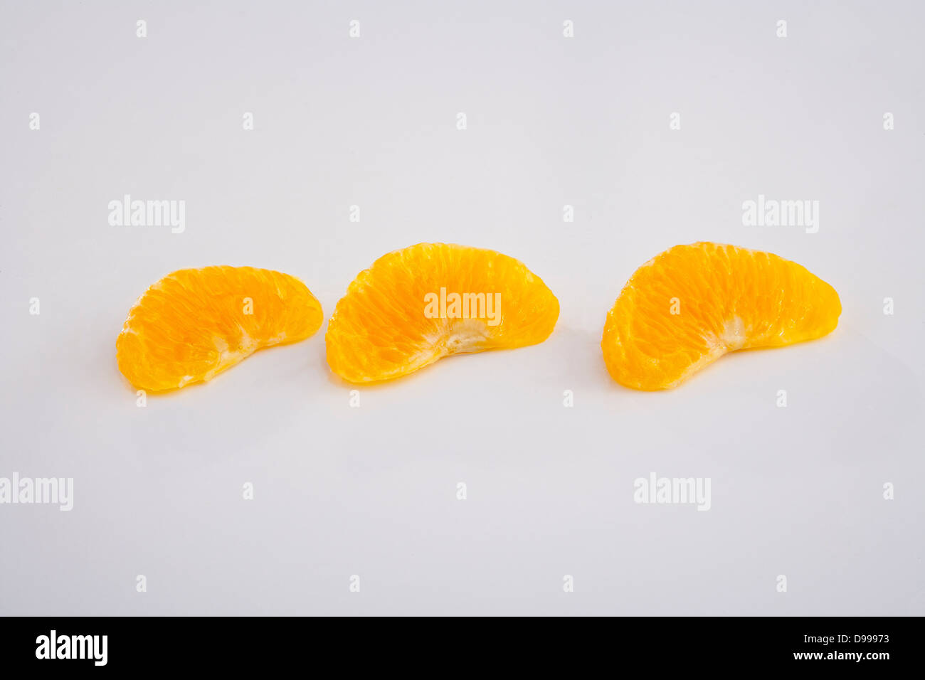Tre spicchi d'arancia e sezioni su bianco Foto Stock