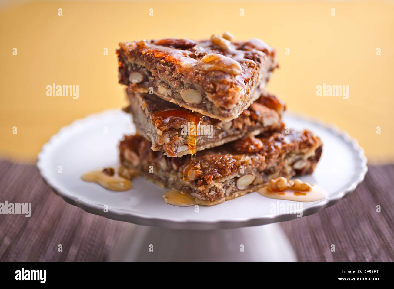 3 pezzi di baklava gocciolamento con miele impilati su una piastra Foto Stock