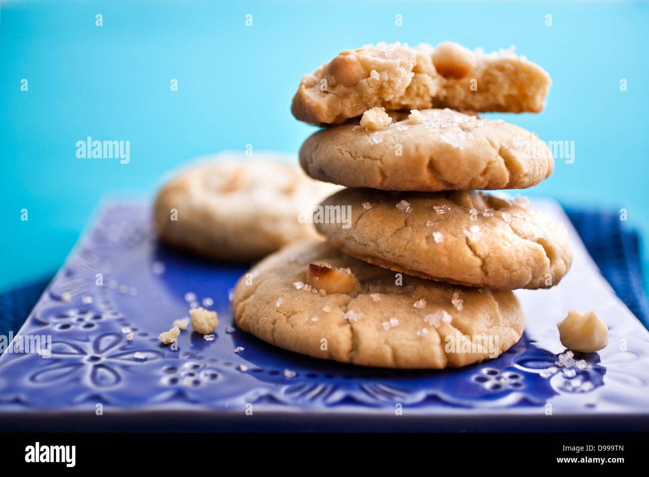 Impilati noce macadamia cookie su una piastra di colore blu Foto Stock
