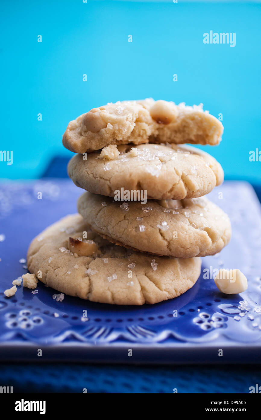 Impilati noce macadamia cookie su una piastra di colore blu Foto Stock