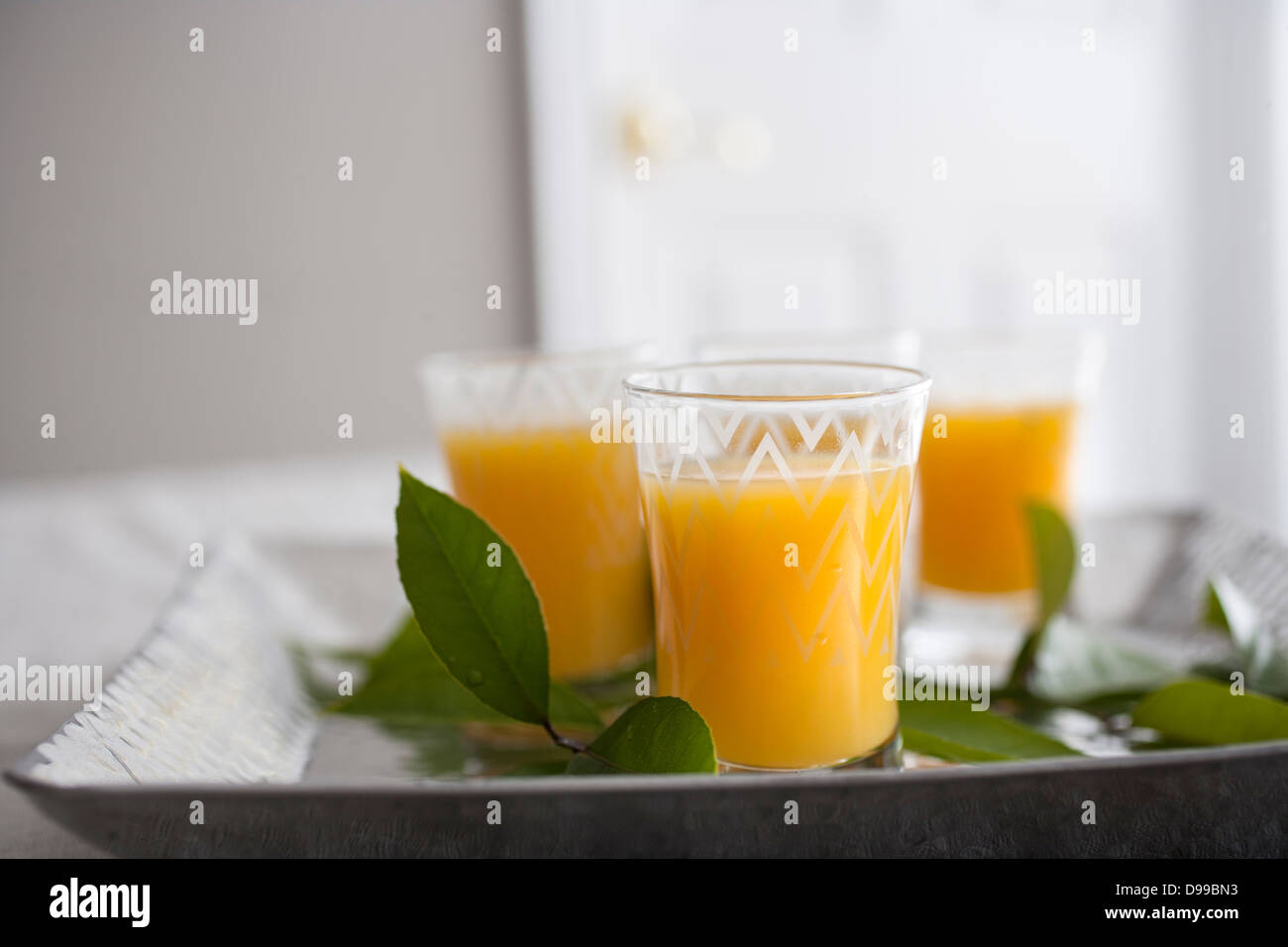 4 bicchieri di succo di frutta appena spremuto su un piatto di portata Foto Stock