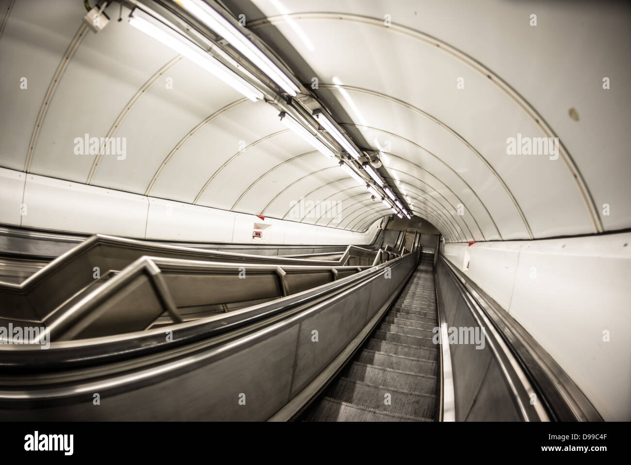 Scale mobili della metropolitana di Londra Londra // LONDRA, Regno Unito - le scale mobili trasportano i passeggeri attraverso la metropolitana di Londra, comunemente nota come la metropolitana, uno dei sistemi metropolitani più antichi e più estesi del mondo. Il caratteristico sistema di scale mobili della metropolitana è una componente vitale della rete, che serve circa 1,35 miliardi di viaggi passeggeri all'anno. Inaugurata nel 1863, la metropolitana di Londra ora comprende 11 linee che coprono 402 chilometri (250 miglia) e servono 272 stazioni. Gli elementi di design iconici della rete, tra cui le scale mobili, il logo della rotonda e la mappa della metropolitana, hanno becom Foto Stock