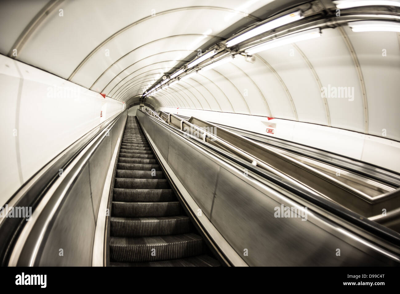 London Underground Escalator Londra Inghilterra // LONDRA, Regno Unito — le scale mobili trasportano i passeggeri attraverso la metropolitana di Londra, comunemente nota come la metropolitana, uno dei sistemi metropolitani più antichi e più estesi del mondo. Il caratteristico sistema di scale mobili della metropolitana è una componente vitale della rete, che serve circa 1,35 miliardi di viaggi passeggeri all'anno. Inaugurata nel 1863, la metropolitana di Londra ora comprende 11 linee che coprono 402 chilometri (250 miglia) e servono 272 stazioni. Gli elementi di design iconici della rete, tra cui le scale mobili, il logo della rotonda e la mappa della metropolitana, hav Foto Stock