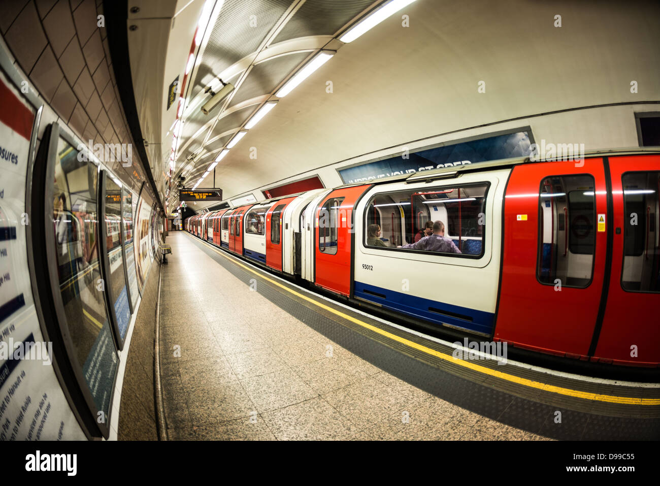 Treno della metropolitana di Londra alla stazione di Londra // LONDRA, Regno Unito — Un treno parte da un binario di una stazione della metropolitana di Londra, parte dell'esteso sistema metropolitano della città comunemente noto come metropolitana. La metropolitana di Londra, inaugurata nel 1863, è la più antica rete ferroviaria sotterranea del mondo e serve milioni di passeggeri ogni giorno in tutta la grande Londra. Il sistema si estende per circa 250 km di binari e collega 270 stazioni attraverso 11 linee diverse, ciascuna identificata da colori e nomi distinti. L'iconica mappa della metropolitana, basata sul design di Harry Beck del 1931, è diventata un riconoscimento globale Foto Stock