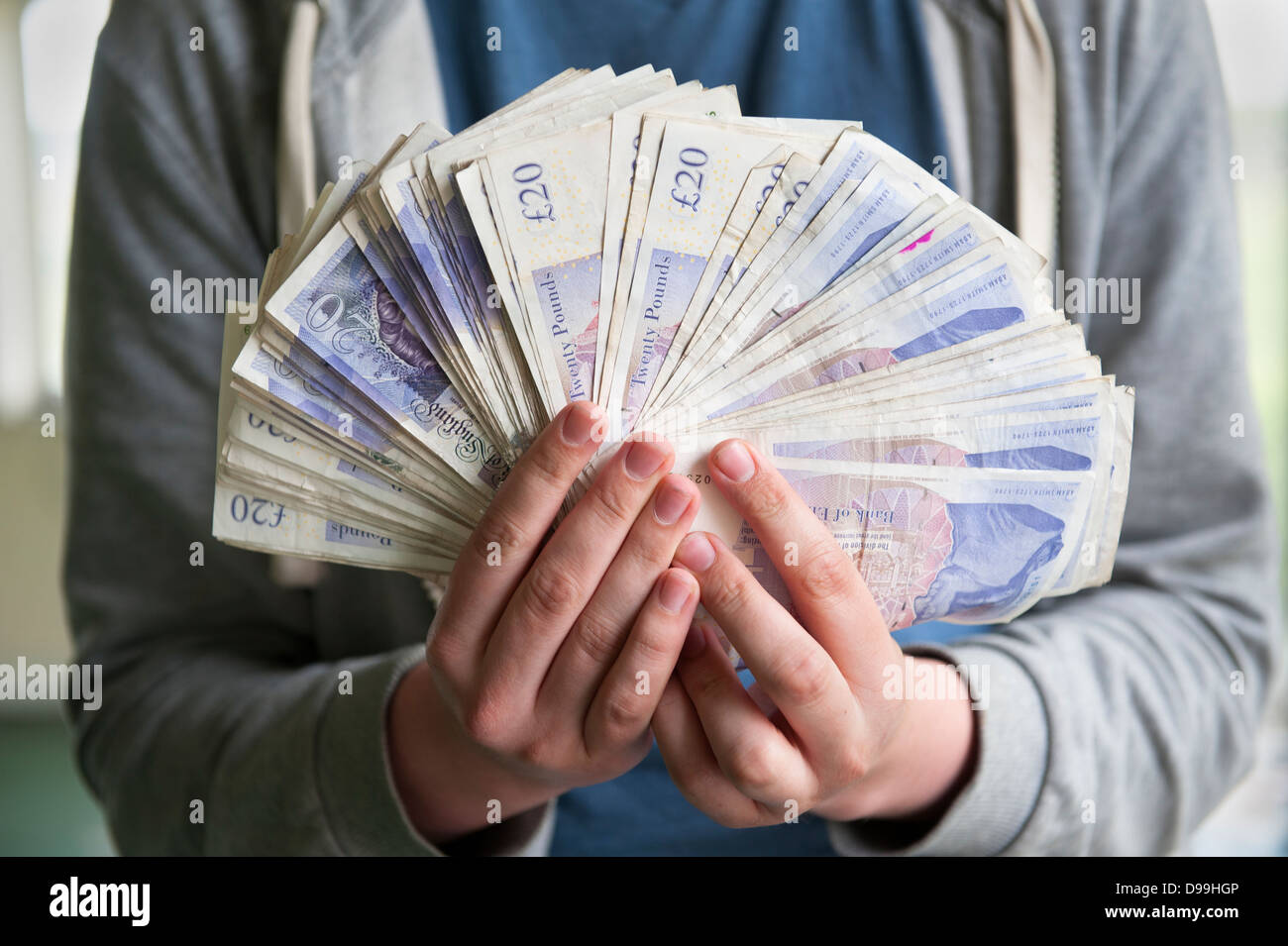 Persona in possesso di tremila sterline a ventaglio in contanti Foto Stock