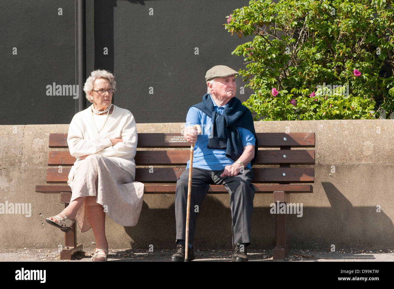 Coppia di anziani seduti su una panchina Foto Stock