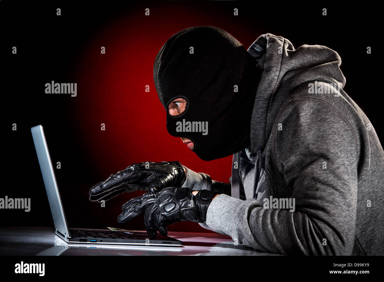 Hacker in una maschera con il computer portatile. Foto Stock
