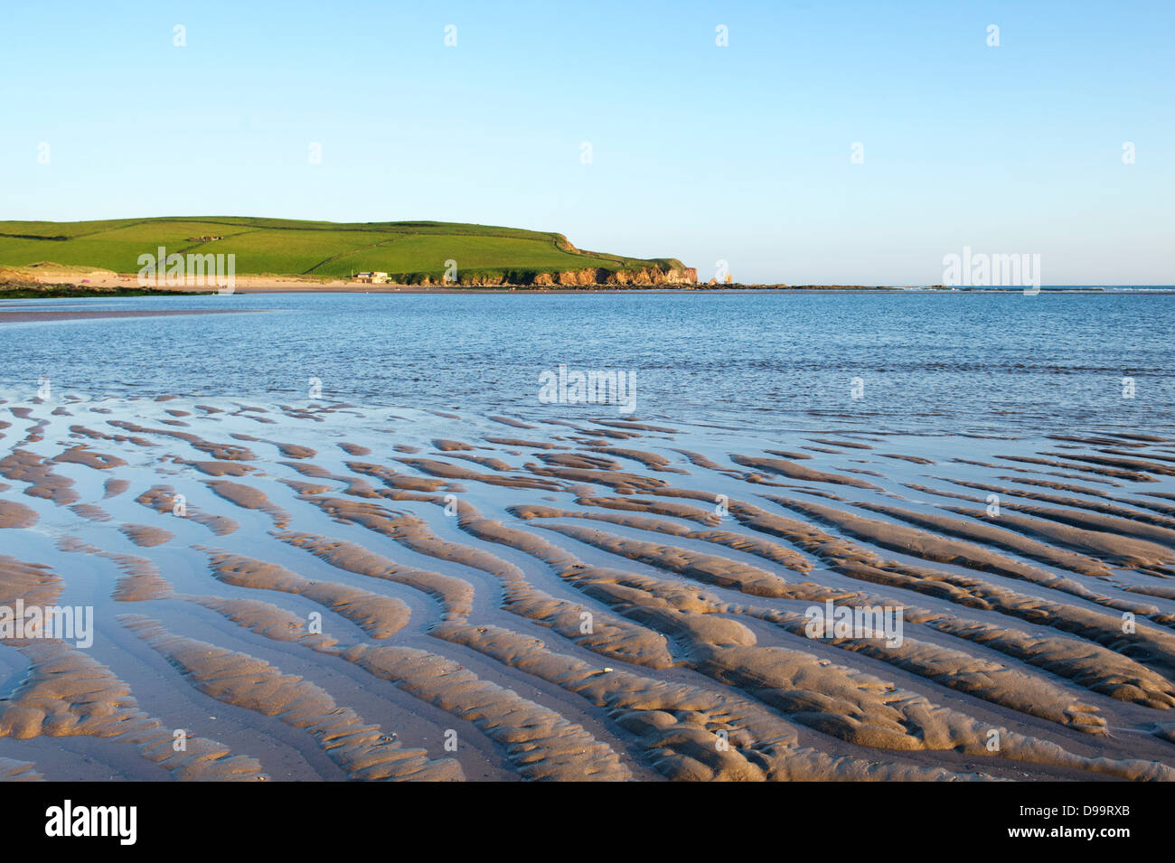 Increspata sabbia e acqua di mare Bantham sulla spiaggia al tramonto. Devon, Inghilterra Foto Stock