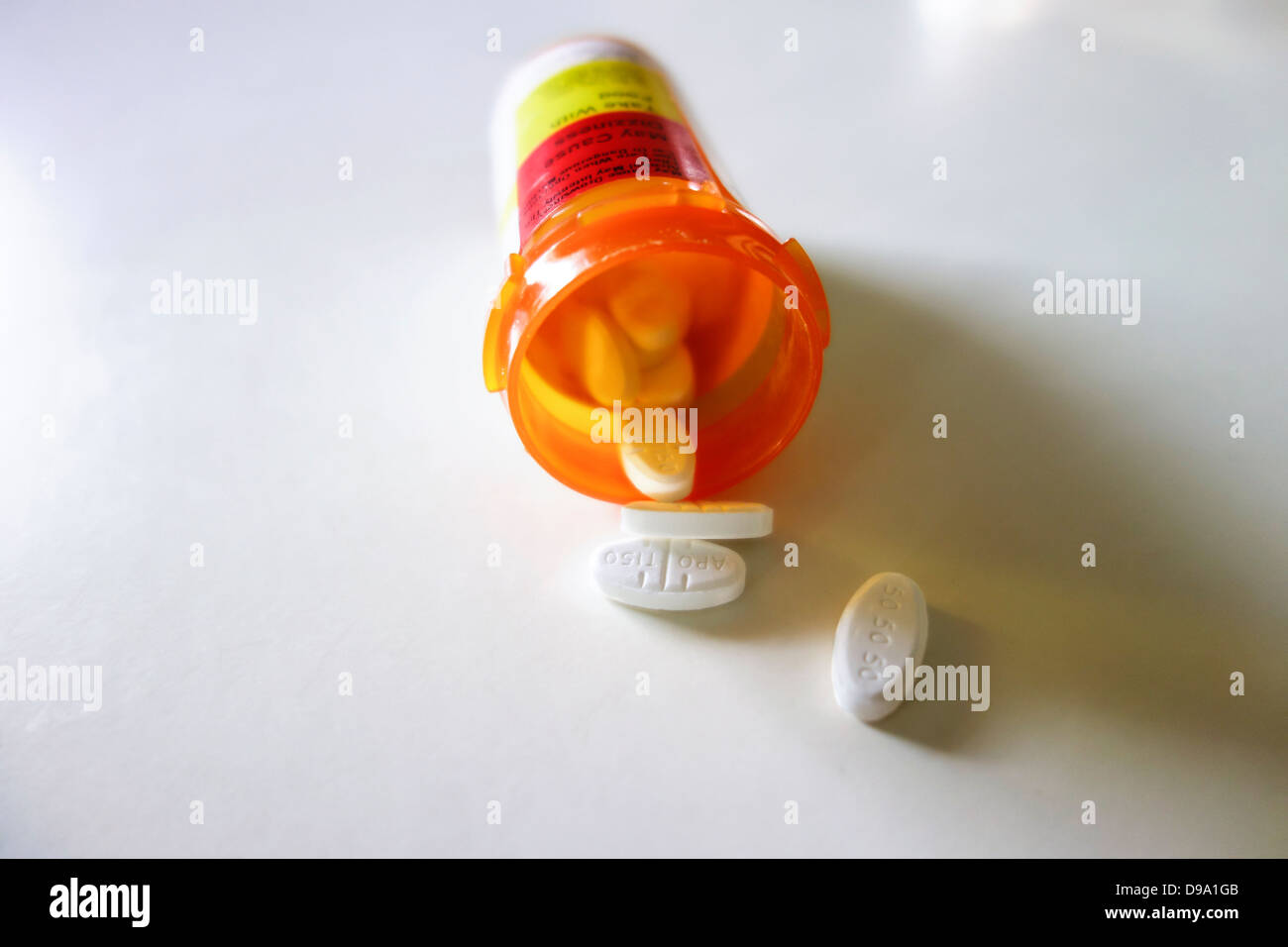Una prescrizione bottiglia giacente sul suo lato con le pillole fuoriuscita. Sfondo bianco. Stati Uniti d'America. Foto Stock