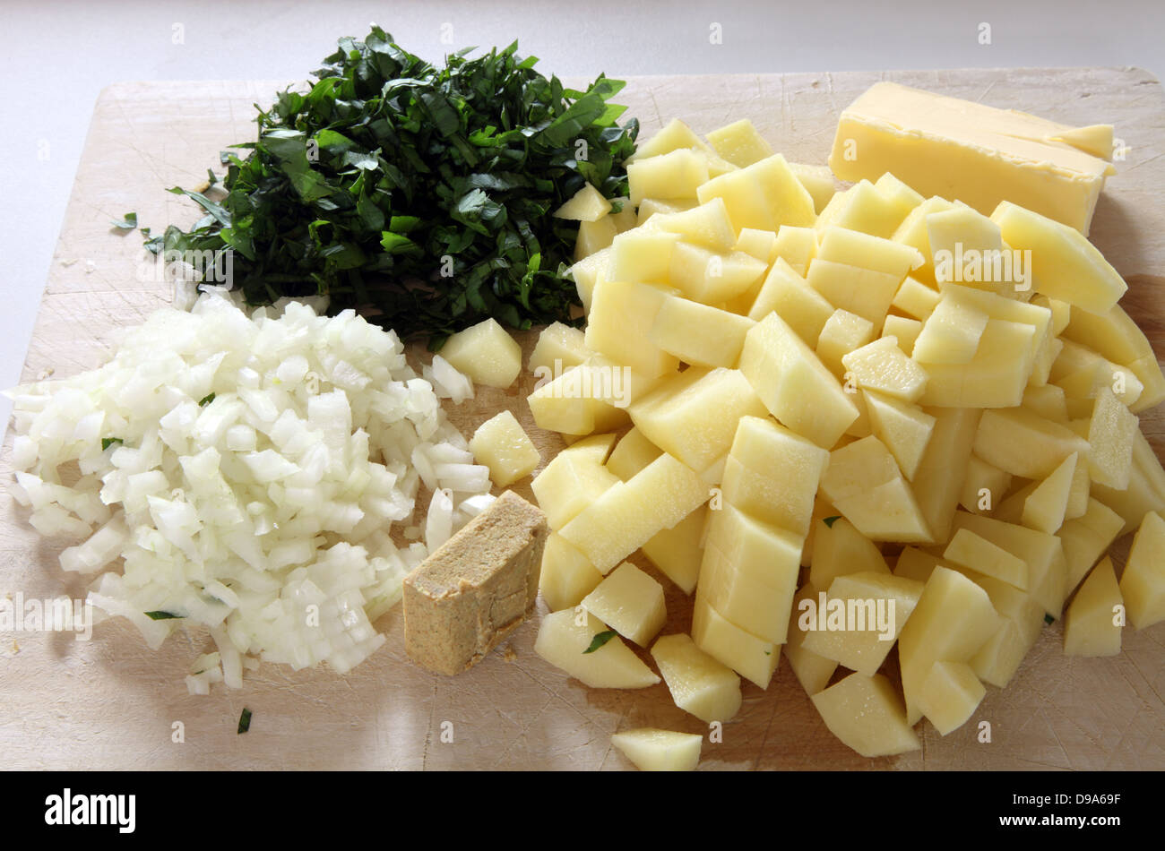 Gli ingredienti per la zuppa di levistico, levistico, tagliata a cubetti di patate, cipolle tritate, il brodo di pollo cubo e burro Foto Stock