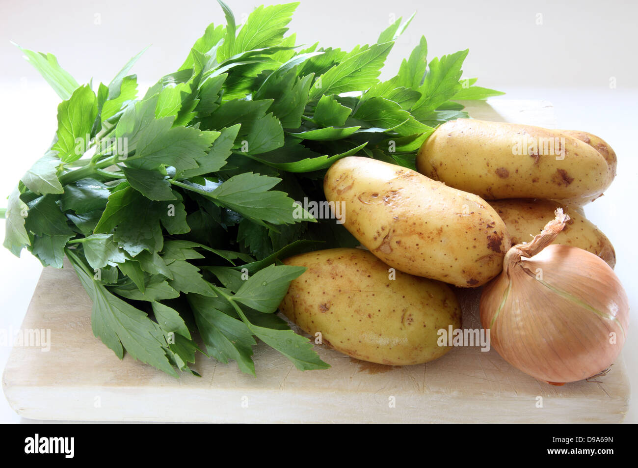 Gli ingredienti grezzi per levistico zuppa, levistico, patate e cipolla Foto Stock