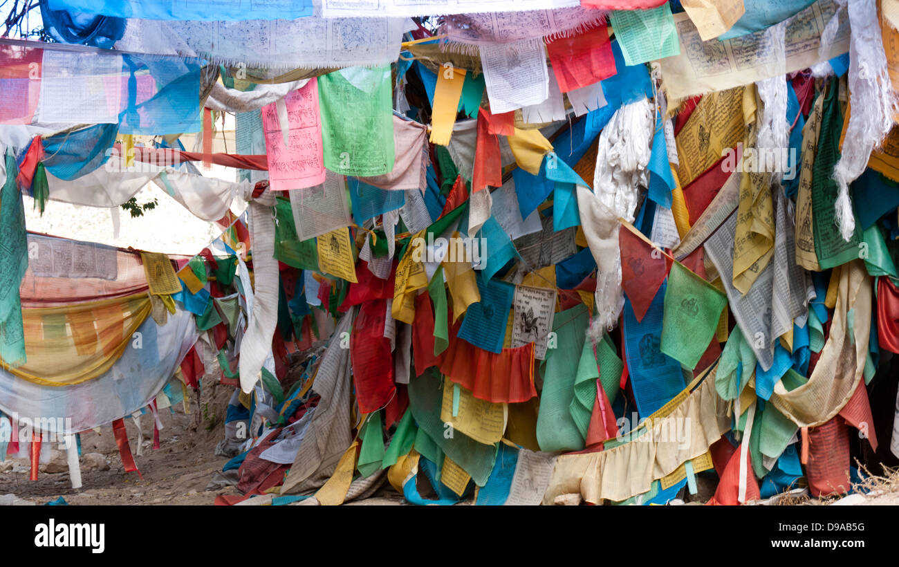 Preghiera tibetano bandiere con il buddismo simboli e preghiere scritto in sanscrito sono state utilizzate nel buddismo per centinaia di anni Foto Stock