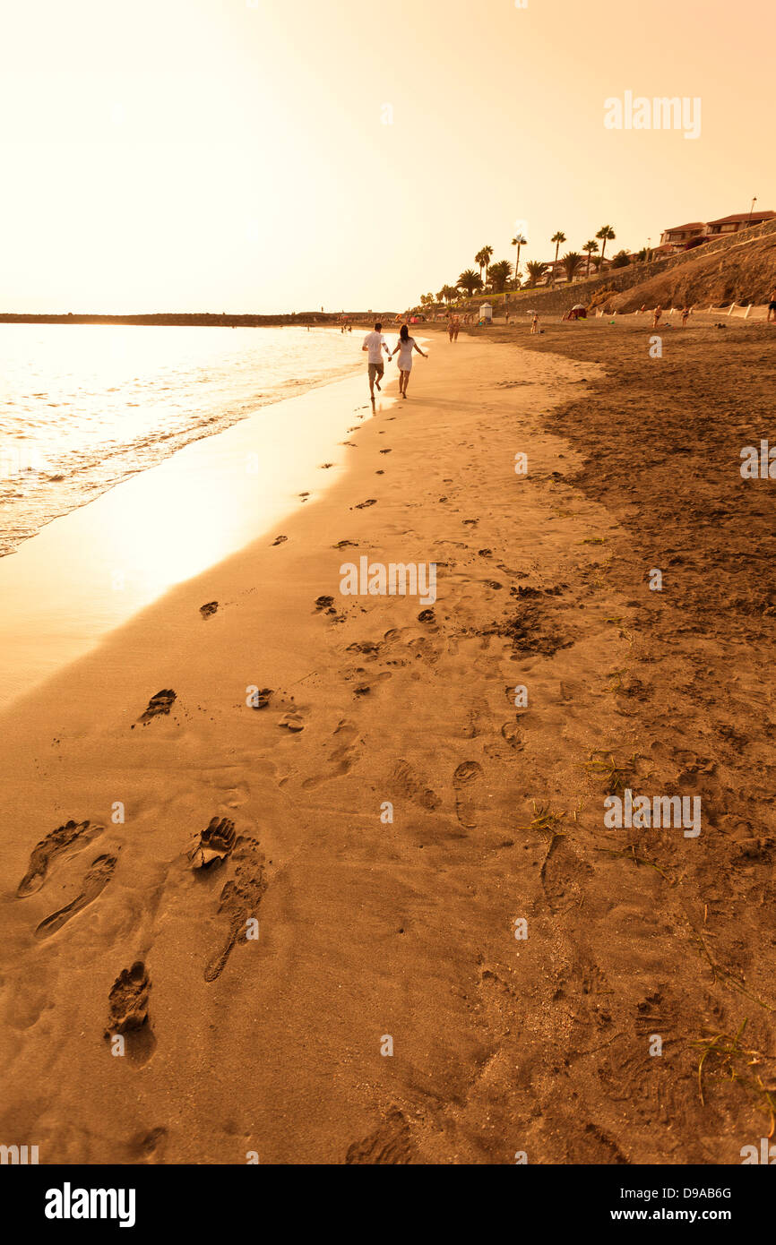 Giovane correre sulla spiaggia mano nella mano Foto Stock