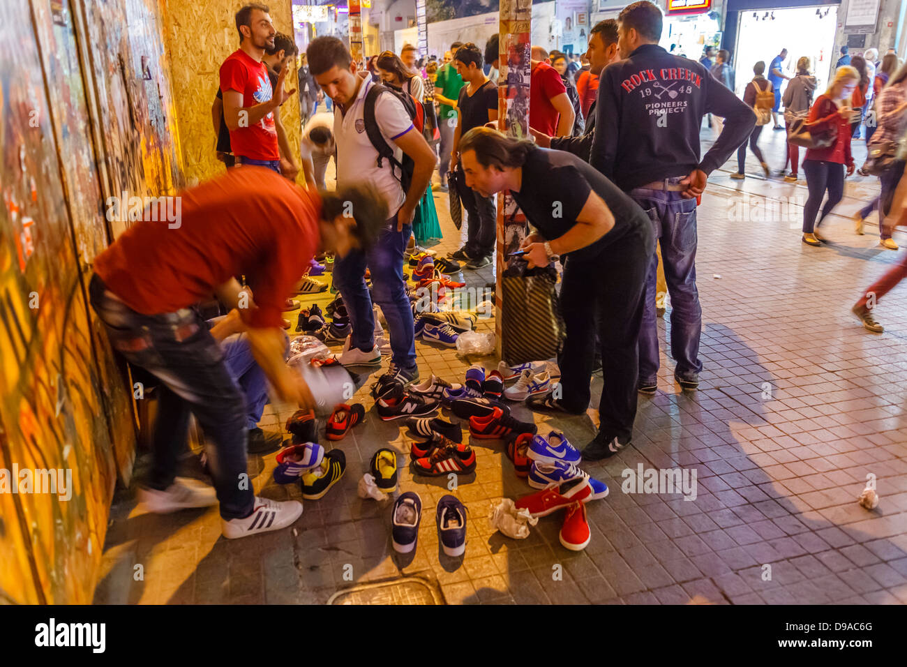 Uomo intraprendente la vendita di scarpe da corsa durante il Taksim Gezi Park proteste, Istanbul, Turchia Foto Stock