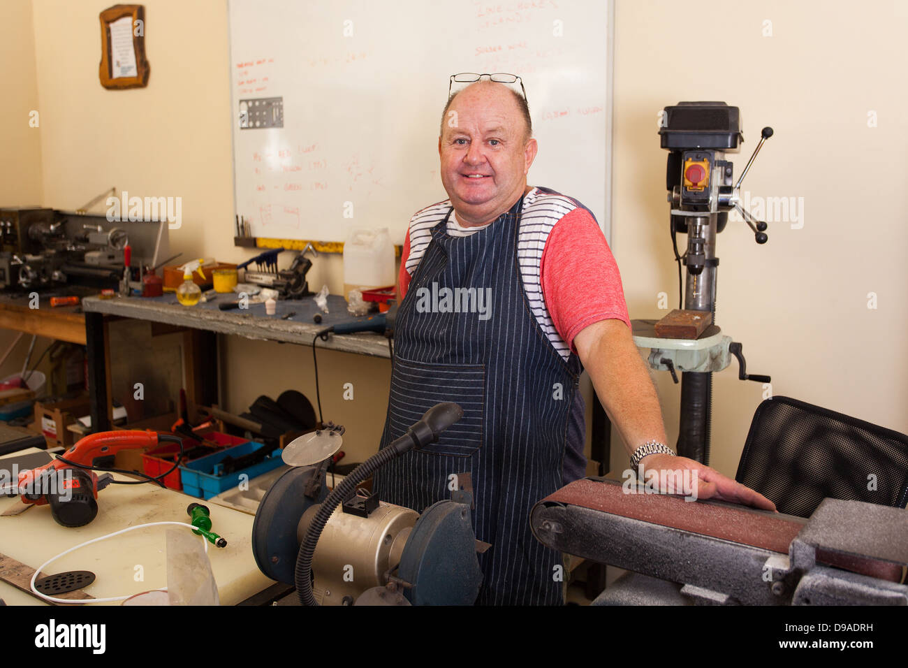 Felice senior macchinista ritratto in officina Foto Stock