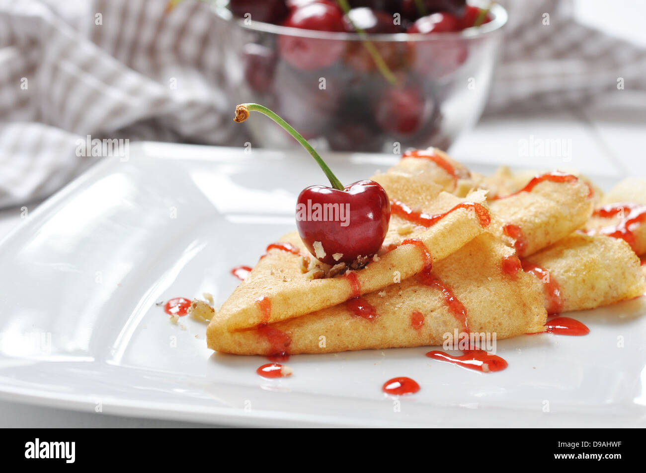 Frittella dolce con salsa alle ciliegie e le ciliegie sulla piastra bianca Foto Stock