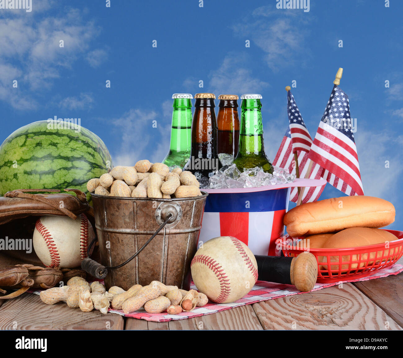 Tavolo da picnic pronto per un quarto di luglio celebrazione. Birra fredda in uno zio Sam Hat, anguria le arachidi e ingranaggio di baseball. Foto Stock
