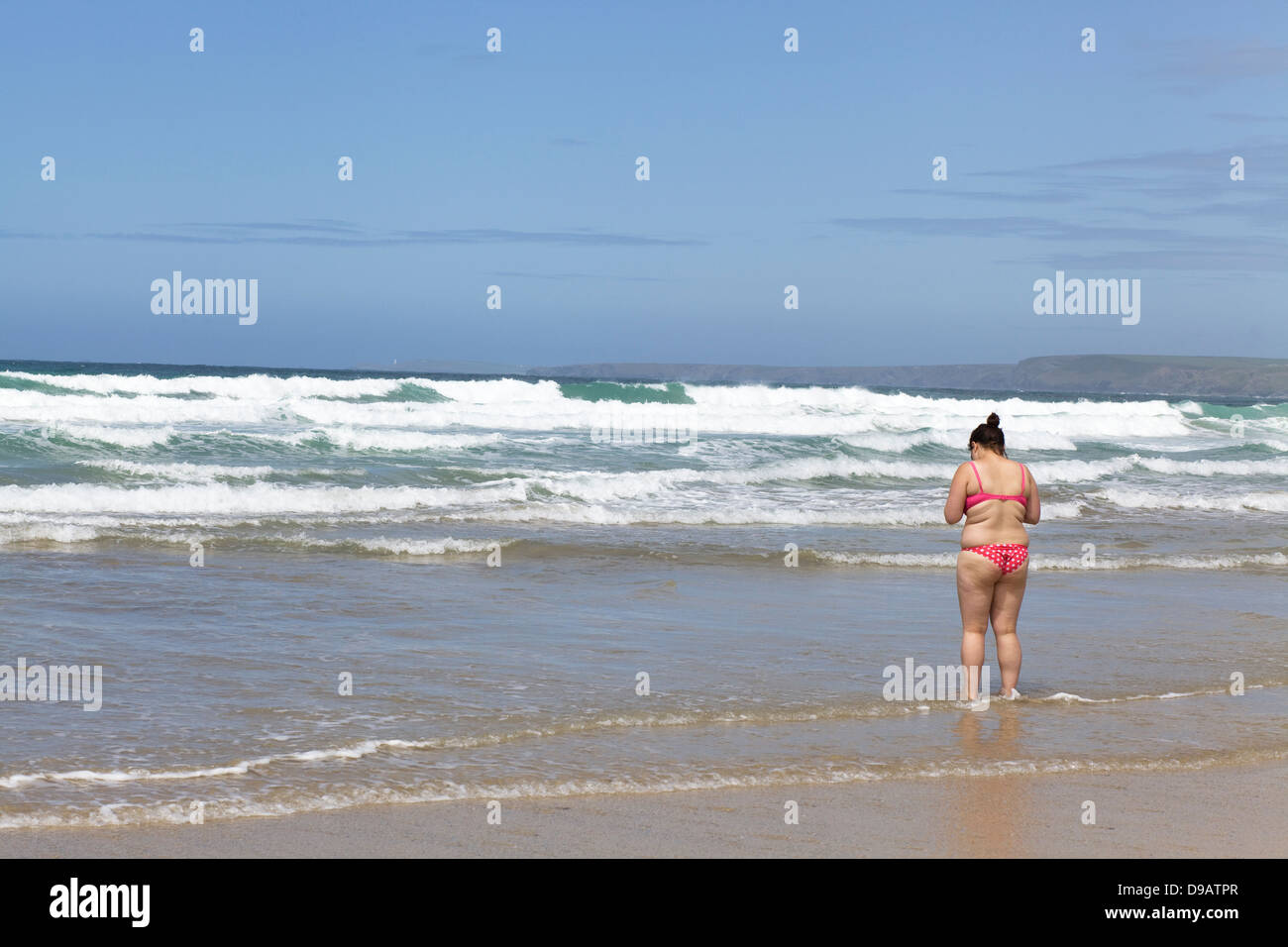 La donna in una rosa Polka Dot Bikini sulla spiaggia di Newquay Cornwall Foto Stock