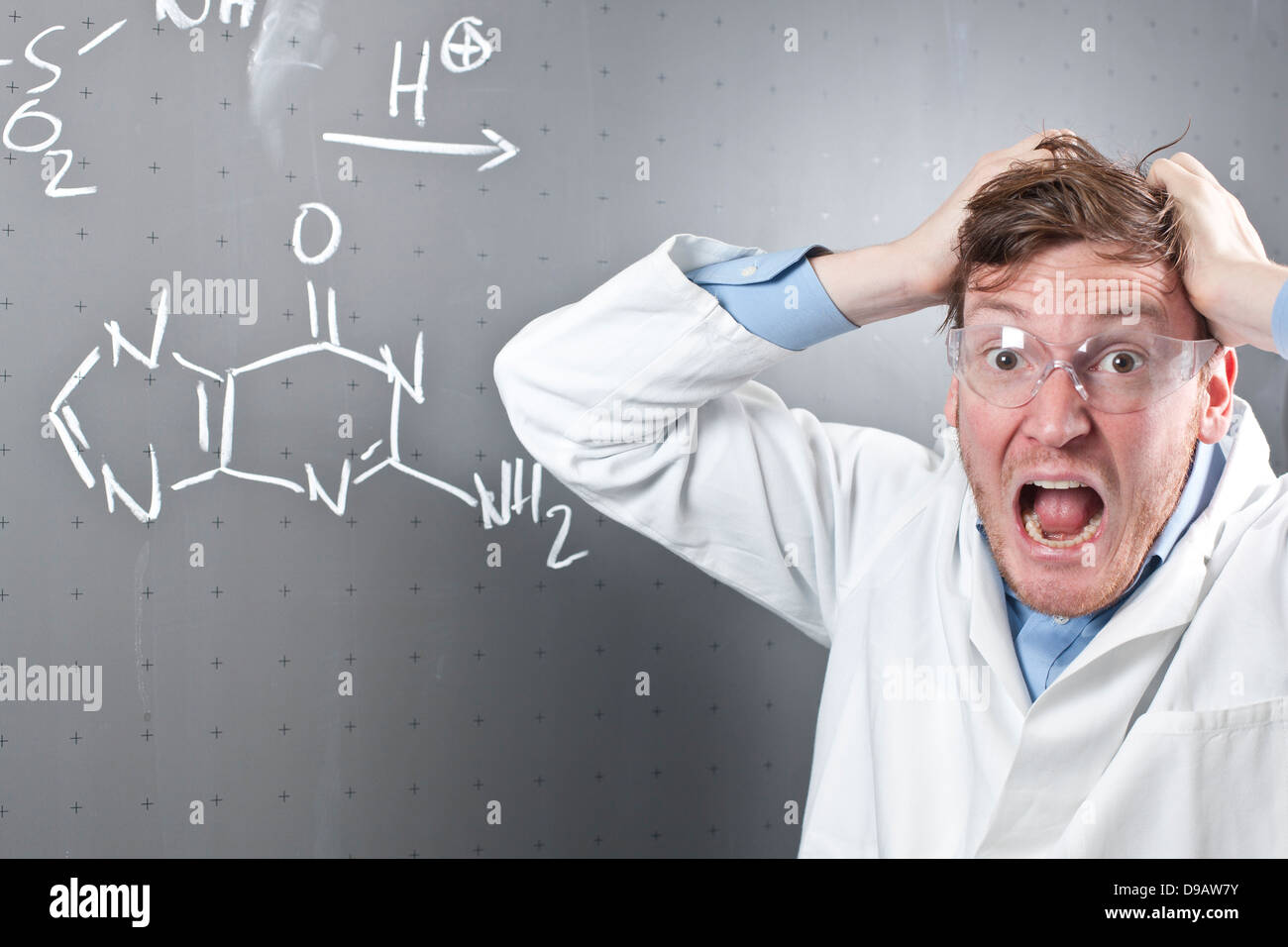 Germania, giovane scienziato con arrabbiato espressione facciale e equazione chimica su chalk board Foto Stock