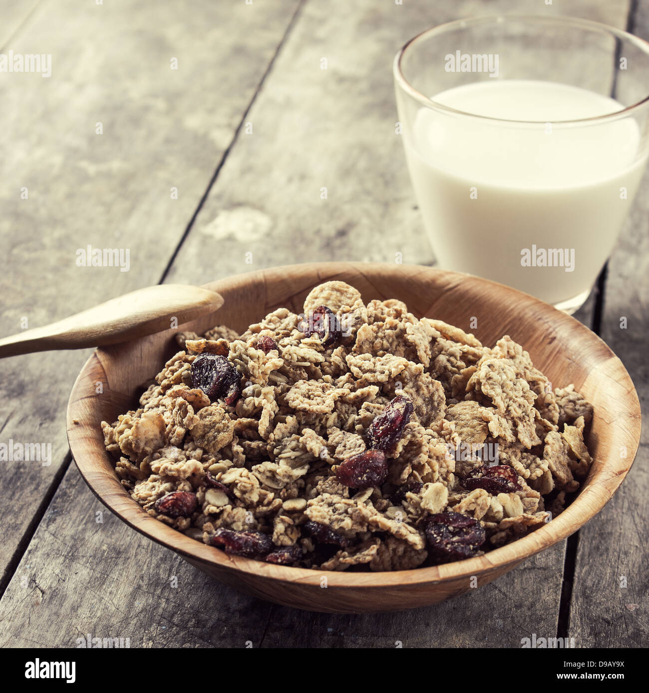Una ciotola di cereale con mirtilli e bicchiere di latte sul tavolo Foto Stock